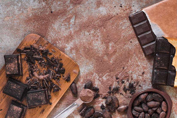 Chocolate pieces bar cocoa powder beans bowls messy table