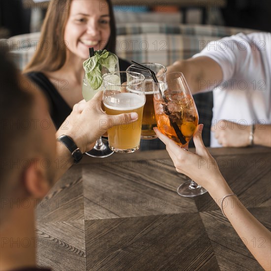 Friends sitting together bar toasting set drinks