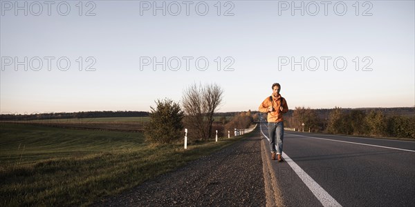 Front view man walking road alone