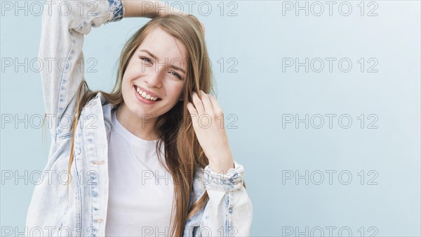 Portrait smiling attractive woman blue wall