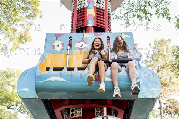 Smiley female friends having fun amusement park