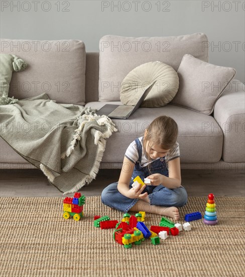 Full shot kid playing floor