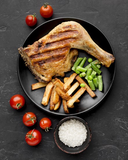 Top view baked chicken potatoes plate with tomatoes