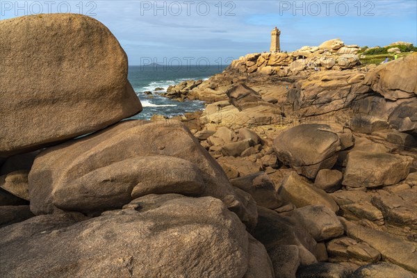 The rocks of the pink granite coast Cote de Granit Rose and the lighthouse Phare de Ploumanac'h near Ploumanac'h