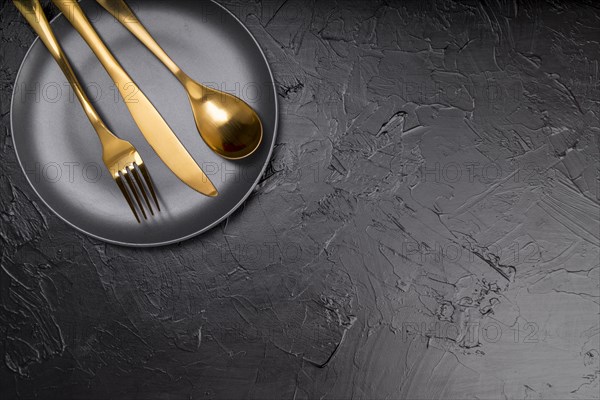 Top view plate with golden cutlery copy space