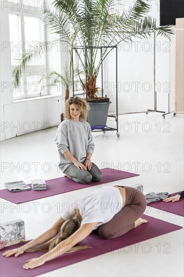 Full shot woman yoga mat stretching