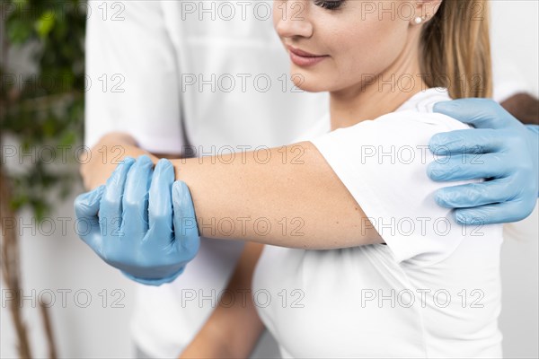 Male physiotherapist checking woman s shoulder flexibility