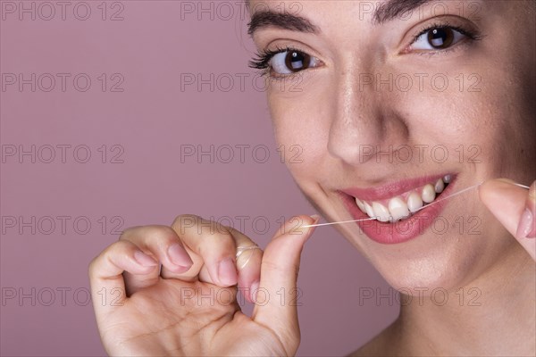Smiley young girl using floss