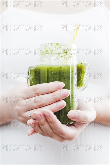 Woman holding bottle green smoothie