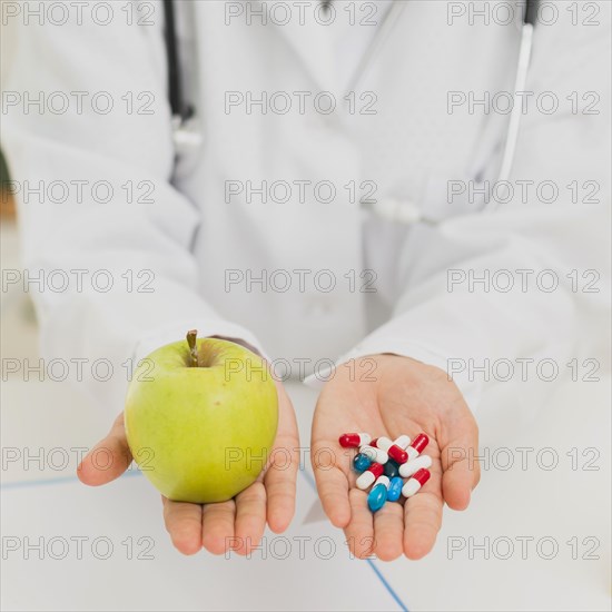 Doctor holding green apple pills