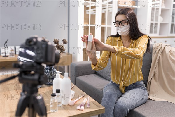 Female vlogger home with camera face mask