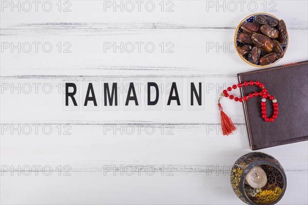 Ramadan text with bowl juicy dates diary red prayer beads white table
