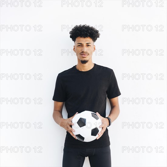 Young black man with ball looking camera