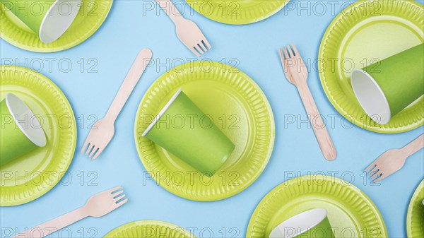Green plates with cups cutlery flat lay