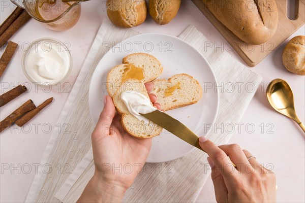Top view woman spreading cream cheese bread