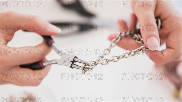 Woman s hand fixing metallic hook with pliers