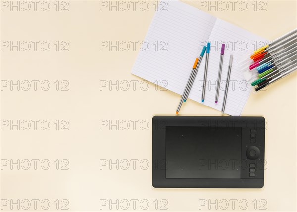 Colorful felt tip pens notebook with graphic digital tablet colored background