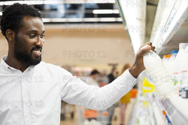 Man inspecting bottle milk grocery store