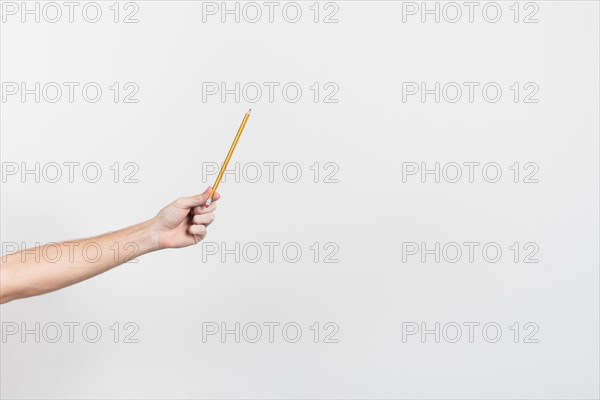 Hand holding pencil with copy space background
