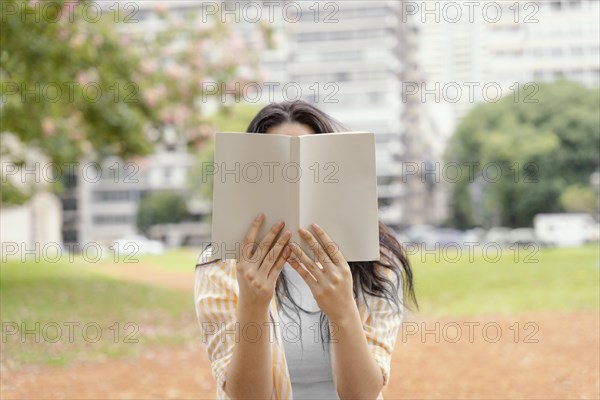 Young woman reading interesting book