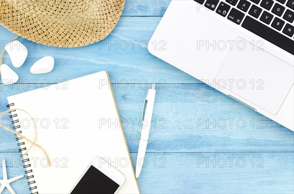 Blank notebook with straw hat laptop