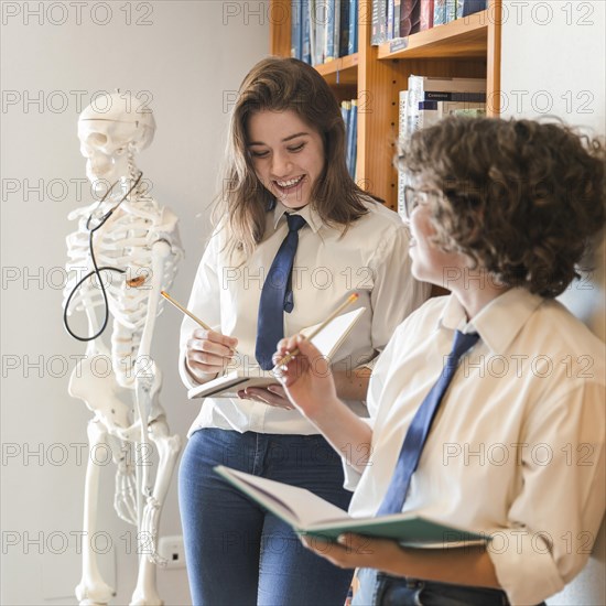 Cheerful teenagers studying library