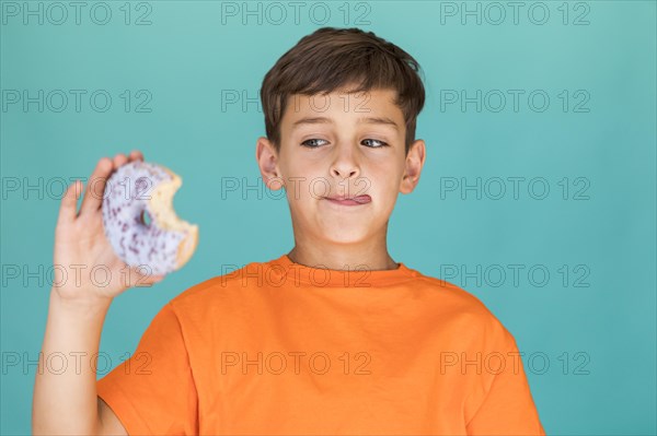 Boy looking delicious glazed doughnut