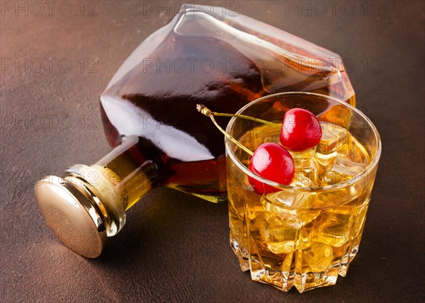High angle whiskey glass cherries with bottle