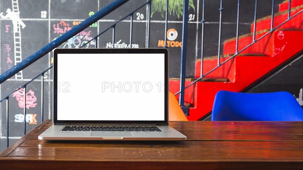 Close up laptop wooden desk front staircase