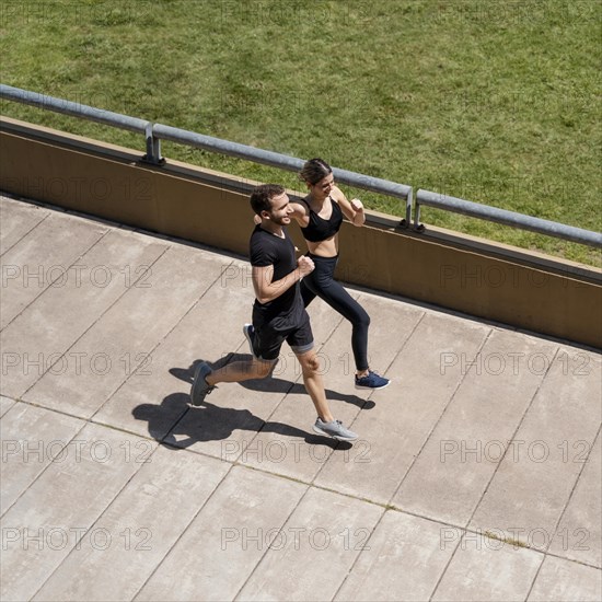 High angle man woman jogging together outdoors