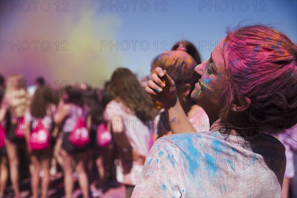 Rear view young woman playing with holi powder