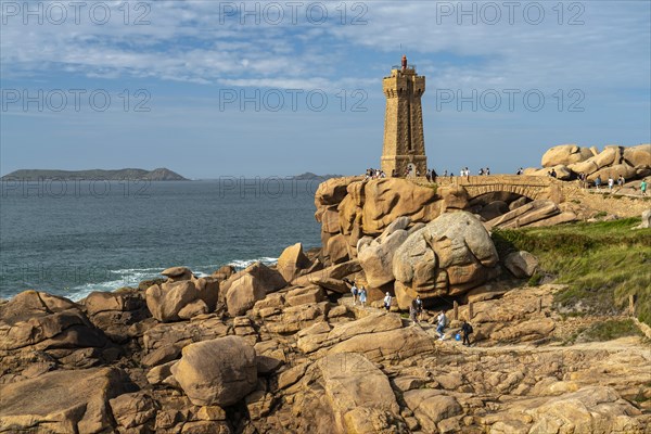 The rocks of the pink granite coast Cote de Granit Rose and the lighthouse Phare de Ploumanac'h near Ploumanac'h