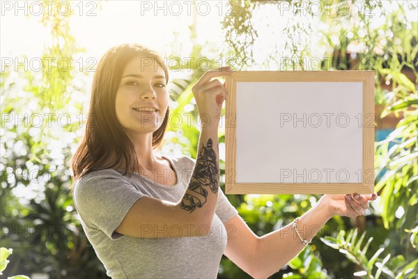 Attractive happy woman holding frame plants
