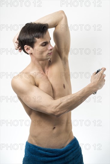 Medium shot man applying deodorant