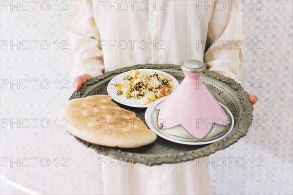 Muslim man holding plate food