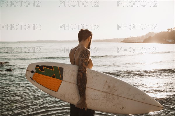 Man standing with surfboard beach