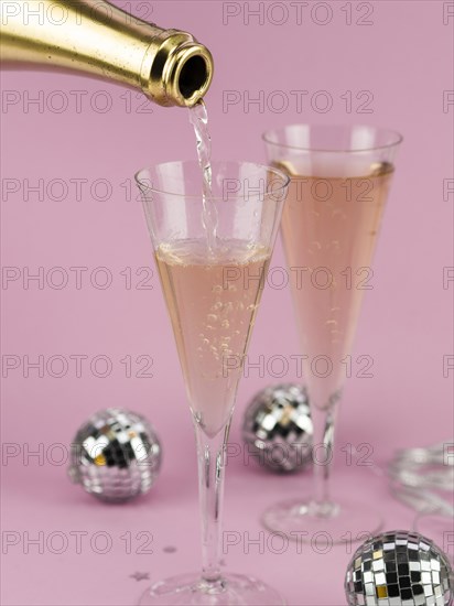 Champagne pouring glass from golden bottle