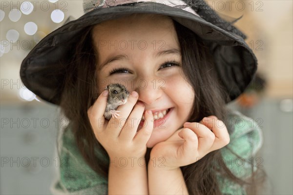 Close up view cute little girl holding hamster