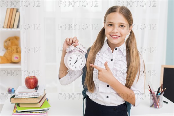 Positive schoolgirl pointing clock