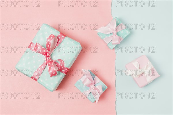 Small big decorated gift boxed tied with ribbon arrange peach blue wallpaper