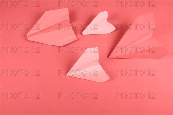 Coral pink paper airplane colored background