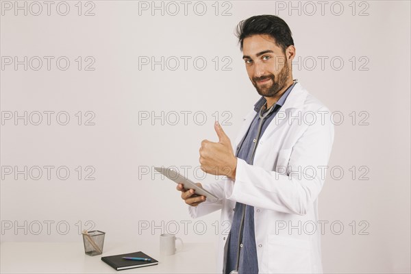 Doctor with ipad thumb up