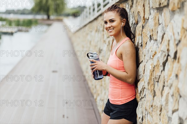 Woman leaning against stone wall