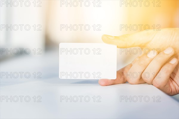 Close up person s hand holding blank white card