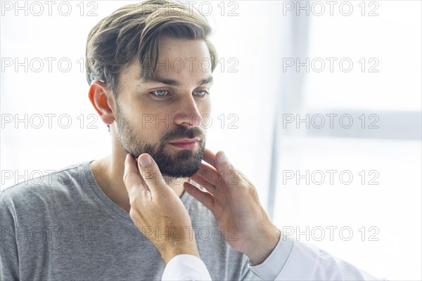 Crop doctor touching lymph nodes young man