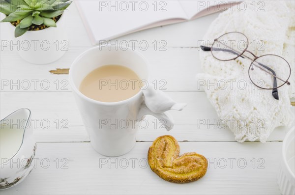 Palmiers elephant ear puff pastry cookie with porcelain white tea cup wooden desk