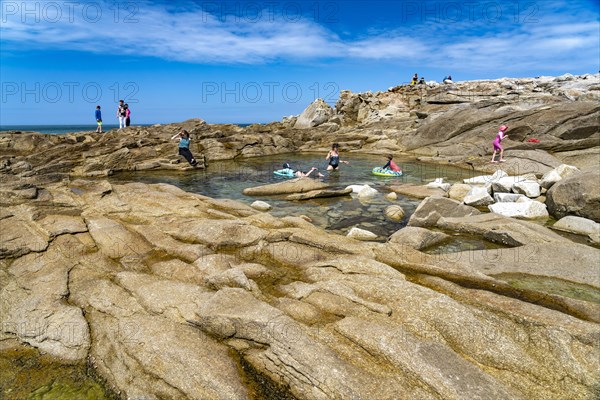 Natural pool among the rocks of the pink granite coast Cote de Granit Rose on the island Ile Grande