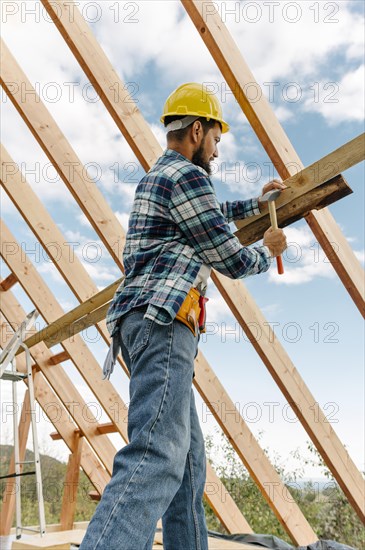 Construction worker with hard hat building roof house