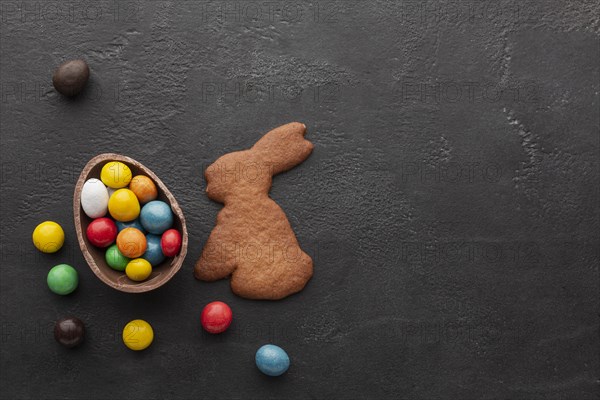 Chocolate easter egg filled with colorful candy bunny shaped cookie
