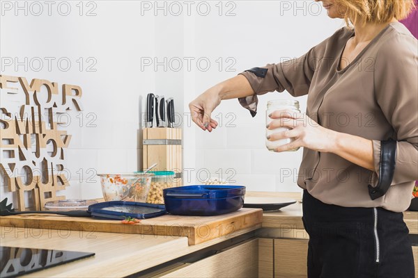 Female standing kitchen salting food